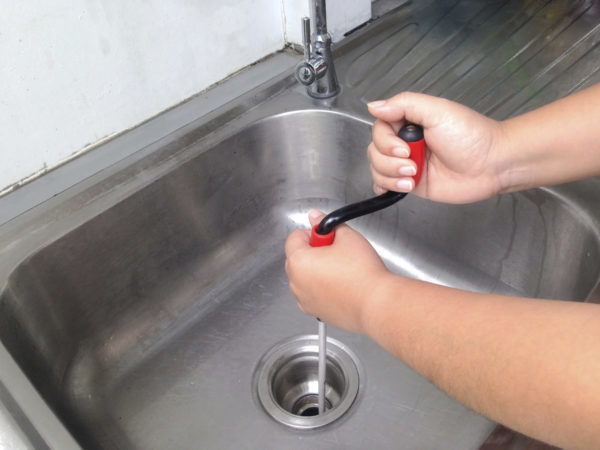 homeowner snaking sink drain at home in Tucson Arizona