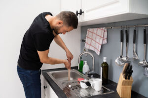 Man plunging clogged sink